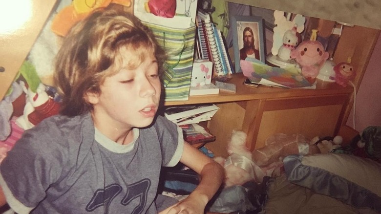 Jennette McCurdy as a child sitting on a bed