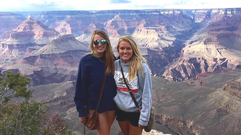 Dressed in a gray hoodie and a pair of shorts, Karoline Leavitt poses with a friend in front of the Grand Canyon