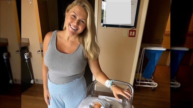 New mom Karoline Leavitt leans against a hospital bassinet while her newborn son sleeps.