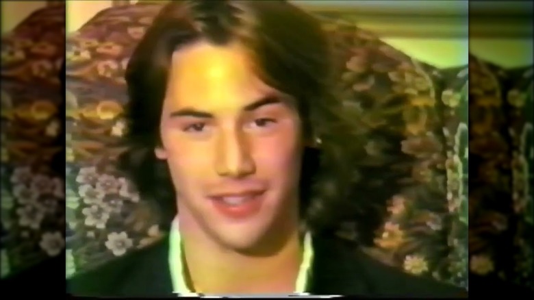 Keanu Reeves at an early audition smiling in a chair