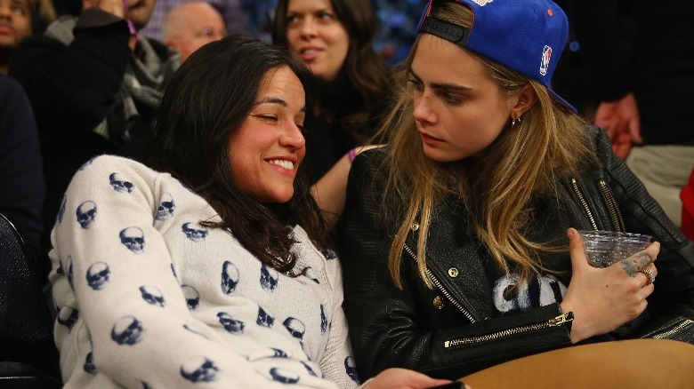 Michelle Rodriguez and Cara Delevingne at a game