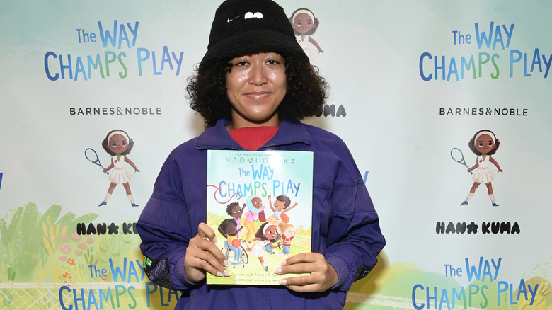 Naomi Osaka holding her children's book