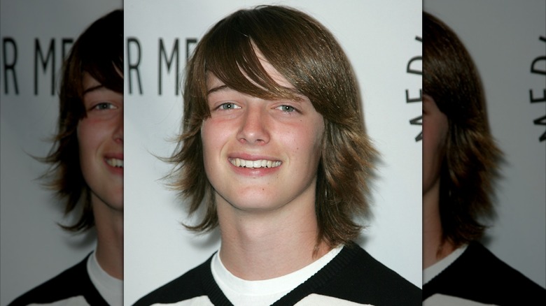 Long-haired Patrick Schwarzenegger as a teenager smiling