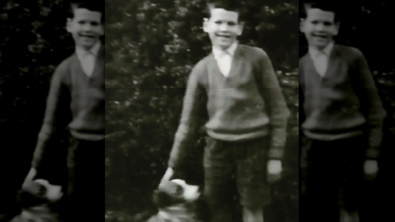 A young Pierce Brosnan petting his dog