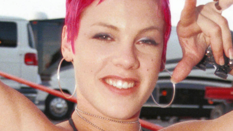 Pink smiling with bright pink hair at age 21