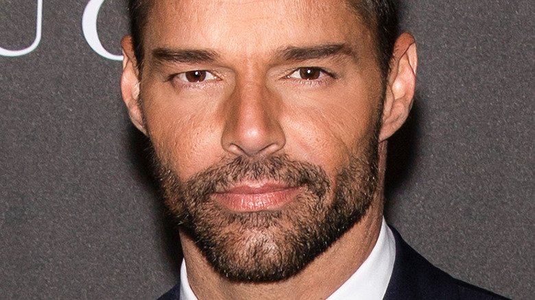 Ricky Martin posing in front of a step and repeat