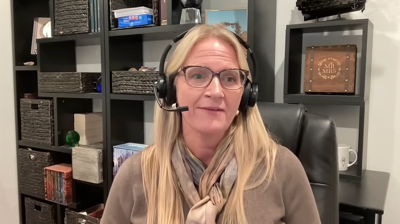 Christine Brown speaks into a headset while seated at a desk
