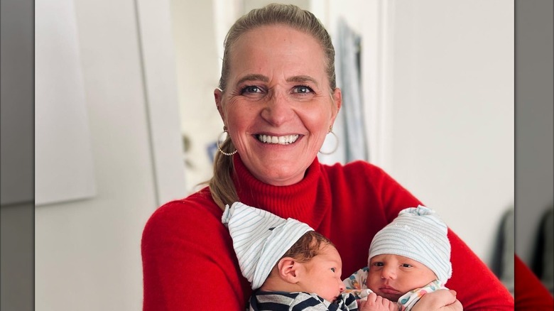 Christine Brown pastes a wide smile while holding her twin grandsons