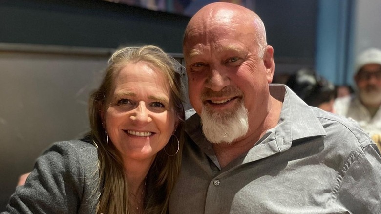 David Woolley wraps his arms around Christine Brown as they both smile for the camera