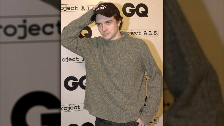 Topher Grace wearing gray sweater