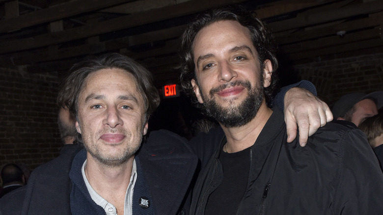 Zach Braff, smirking, stubbly facial hair, longer hair, standing next to Nick Cordero, who's also smiling, 2019 photo