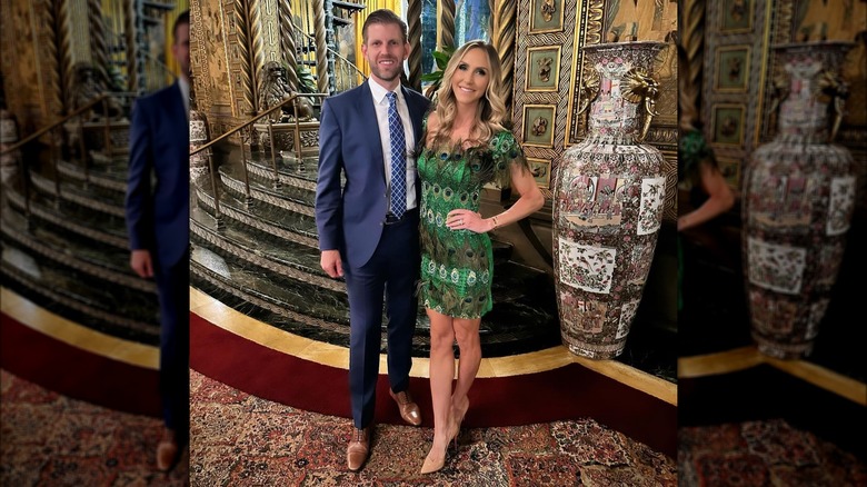 Lara Trump wearing peacock feather dress and posing with Eric Trump inside Mar-a-Lago