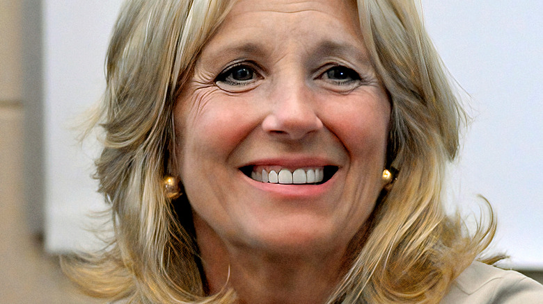 Jill Biden smiling and wearing gold earrings