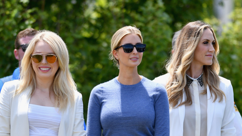 Tiffany, Ivanka, and Lara Trump posing together outside in sunglasses