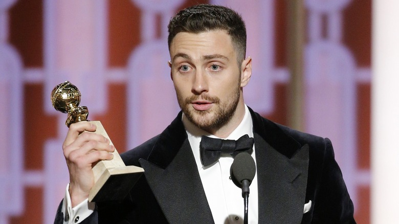 Aaron Taylor-Johnson holding his Golden Globe trophy