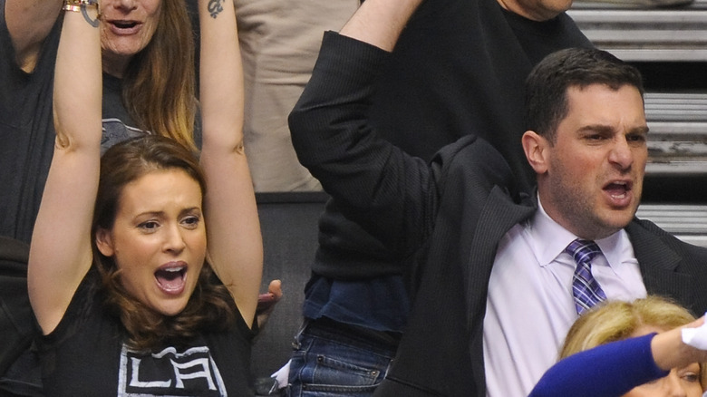 Alyssa Milano and her husband David Bugliari cheering at a basketball game
