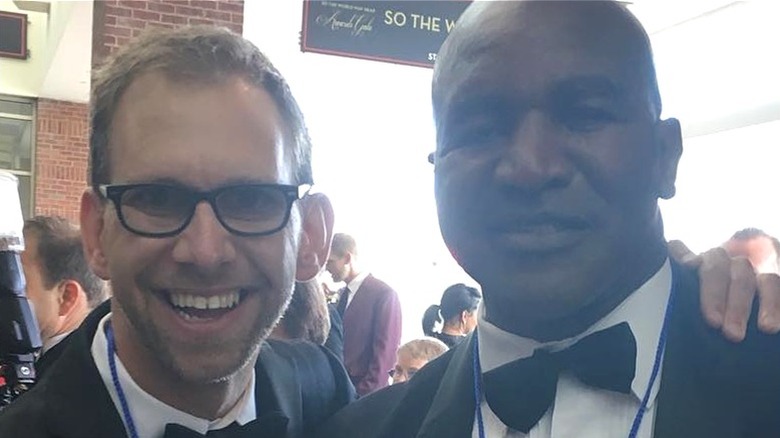 Michael Kutcher smiling next to a friend