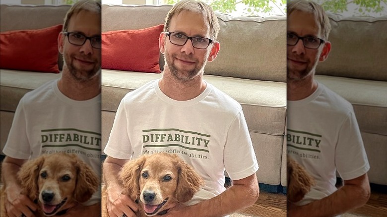 Michael Kutcher smiling with his dog