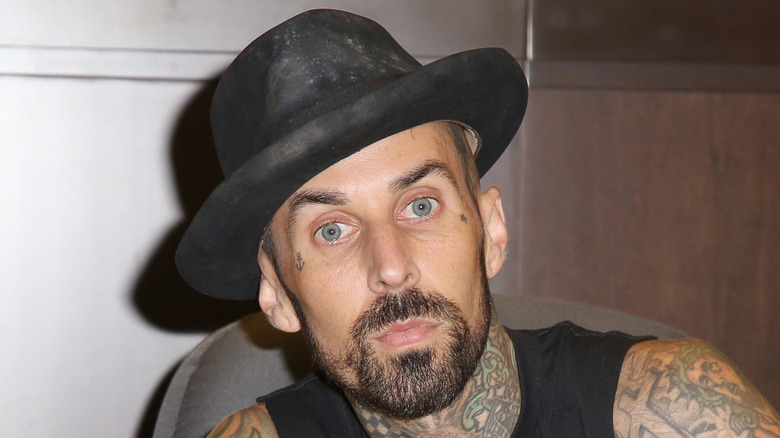Travis Barker wearing hat with serious expression at a book signing