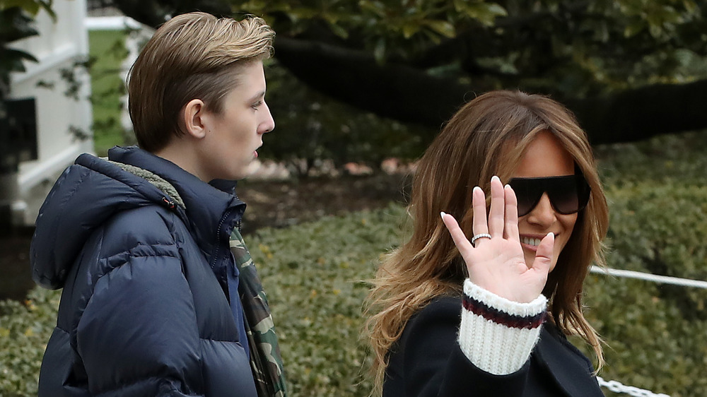 Barron Trump walking with Melania Trump as she waves goodbye