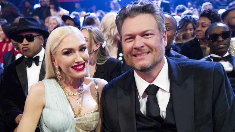 Gwen Stefani and Blake Shelton sitting and posing