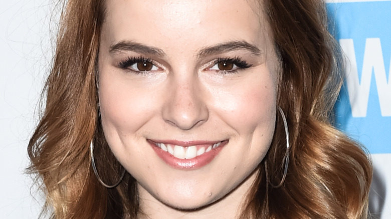 Bridgit Mendler wears hoop earrings and smiles