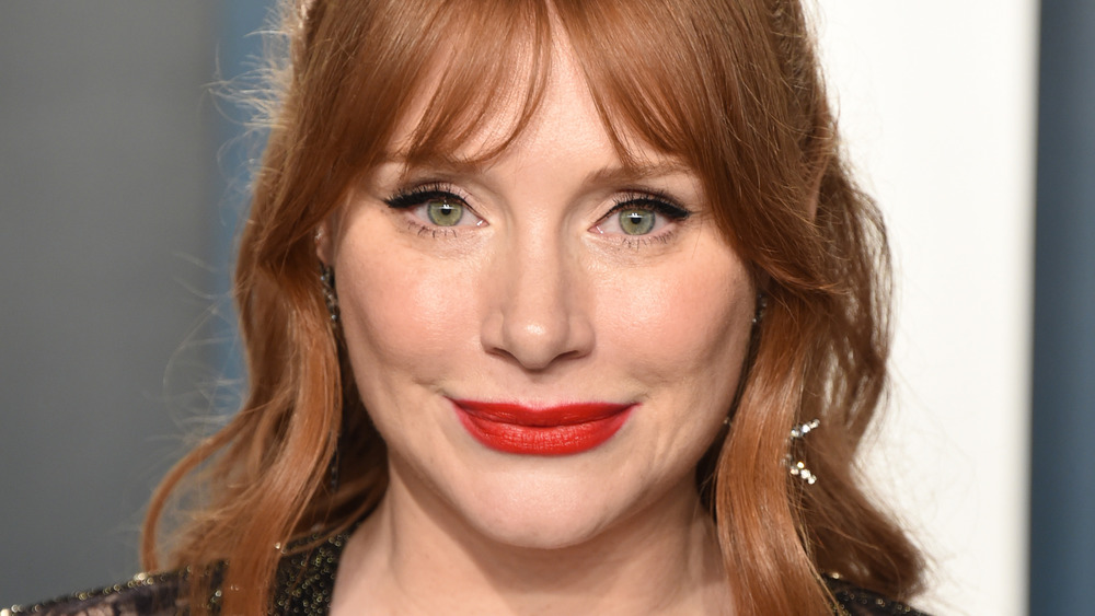 Bryce Dallas Howard wears red lipstick and smiles at an event