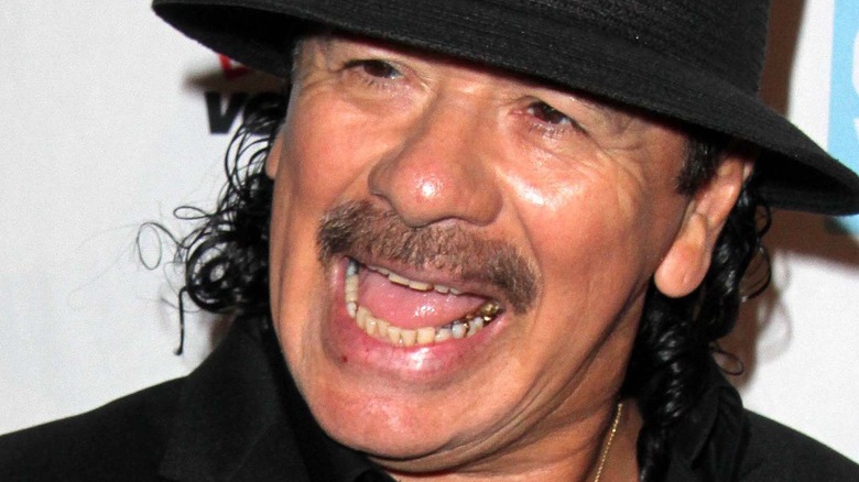 Carlos Santana laughing moustache black hat