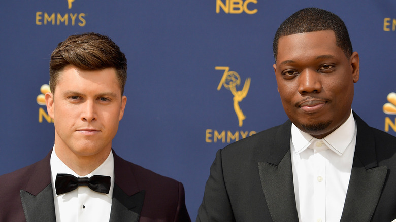 Colin Jost and Michael Che standing together