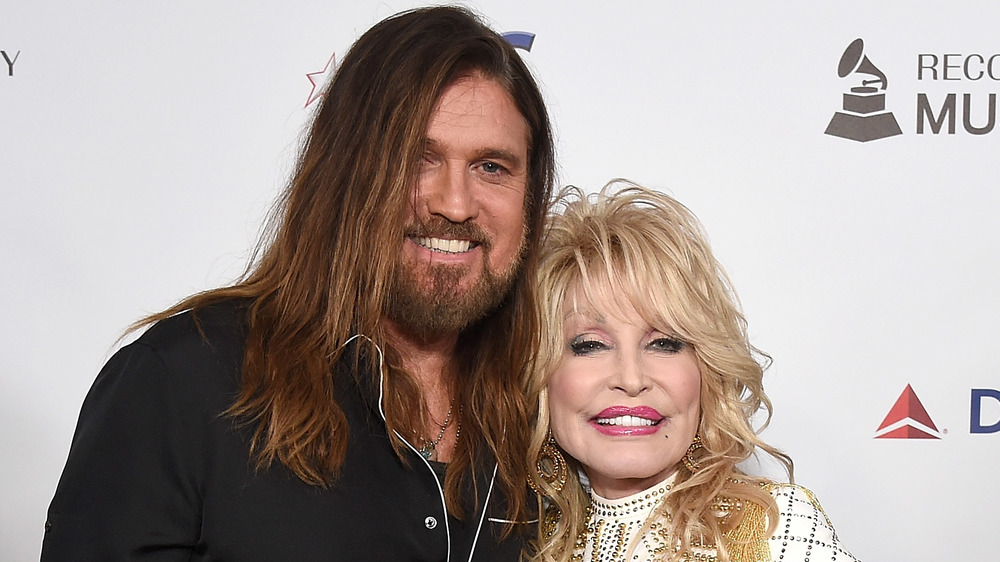 Billy Ray Cyrus and Dolly Parton embracing on the red carpet