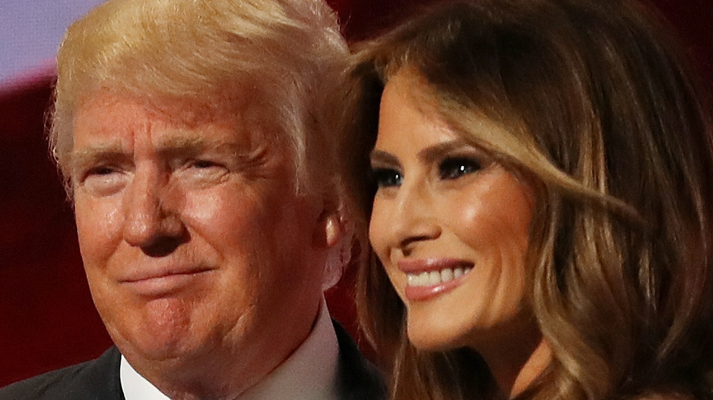 Donald Trump and Melania Trump smiling on stage