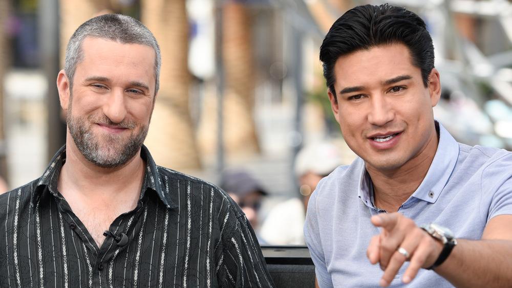 Dustin Diamond and Mario Lopez sitting down and talking on couch with Lopez pointing