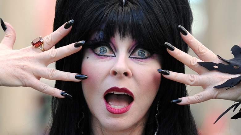 Elvira fingers by face