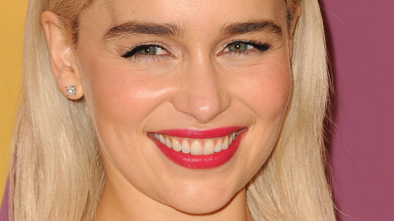 Emilia Clarke smiles in red lipstick