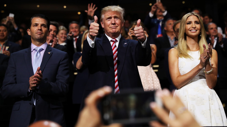 Donald Trump Jr., Donald Trump, and Ivanka Trump clapping in a crowd