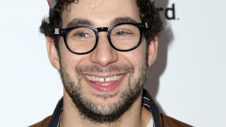 Jack Antonoff smiling and wearing glasses