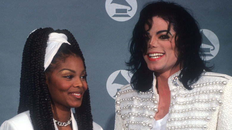 Janet and Michael Jackson, both smiling on red carpet