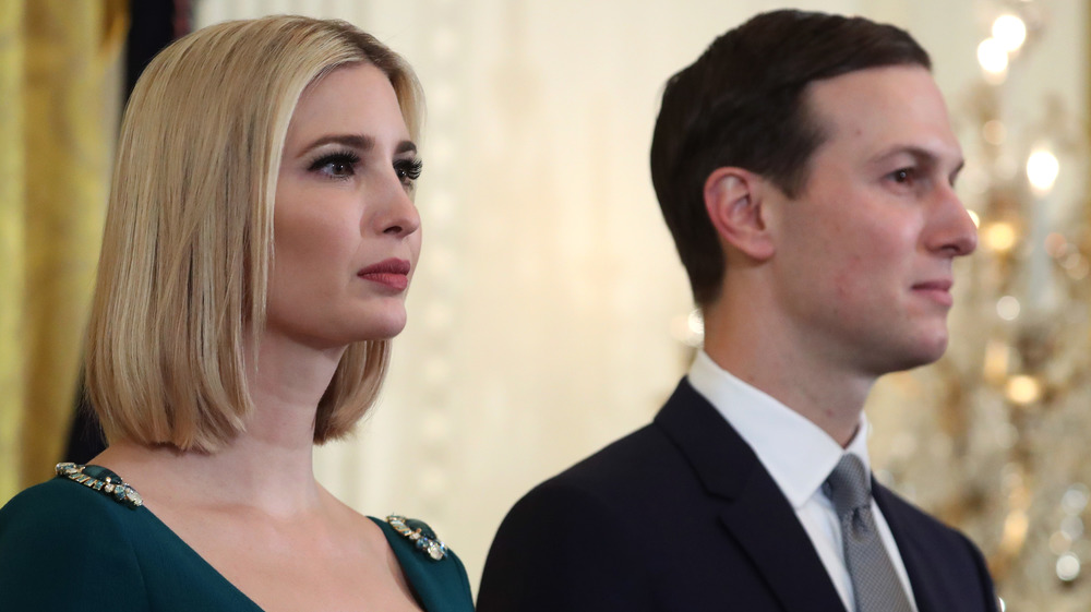 Ivanka Trump and Jared Kushner stand at an event