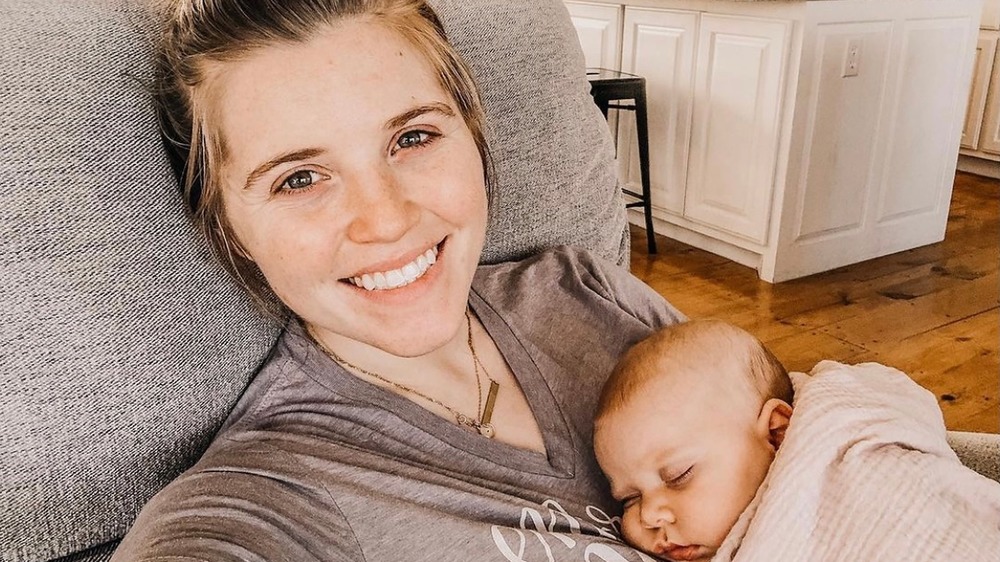 Joy-Anna Duggar, selfie, no makeup, hair in bun, holding sleeping baby 