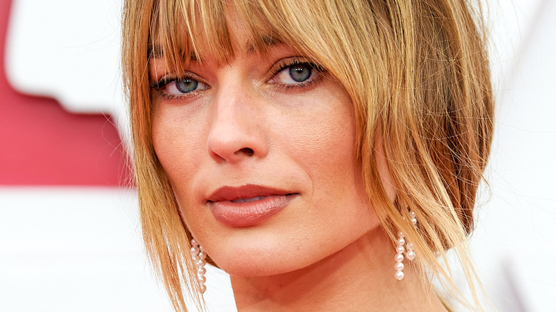 Margot Robbie with bangs and slight smile