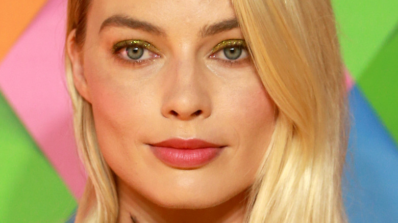 Margot Robbie with slight smile and pink lipstick