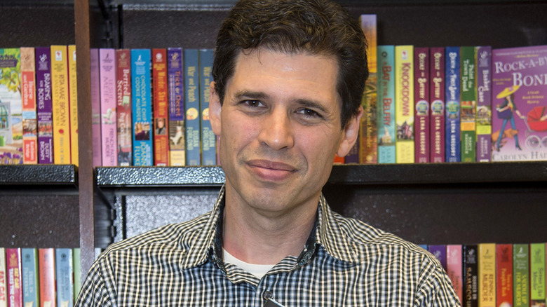 Max Brooks in front of bookshelf