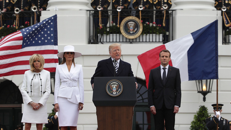 President Donald Trump (3rd L) speaking as U.S. first lady Melania Trump (2nd L), French President Emmanuel Macron (R) and French first lady Brigitte Macron (L) listen