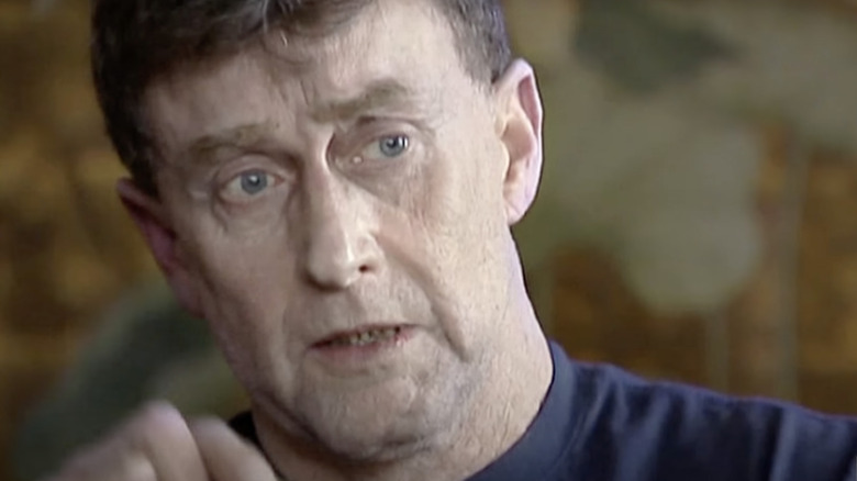 Michael Peterson tears up while half-smiling. 