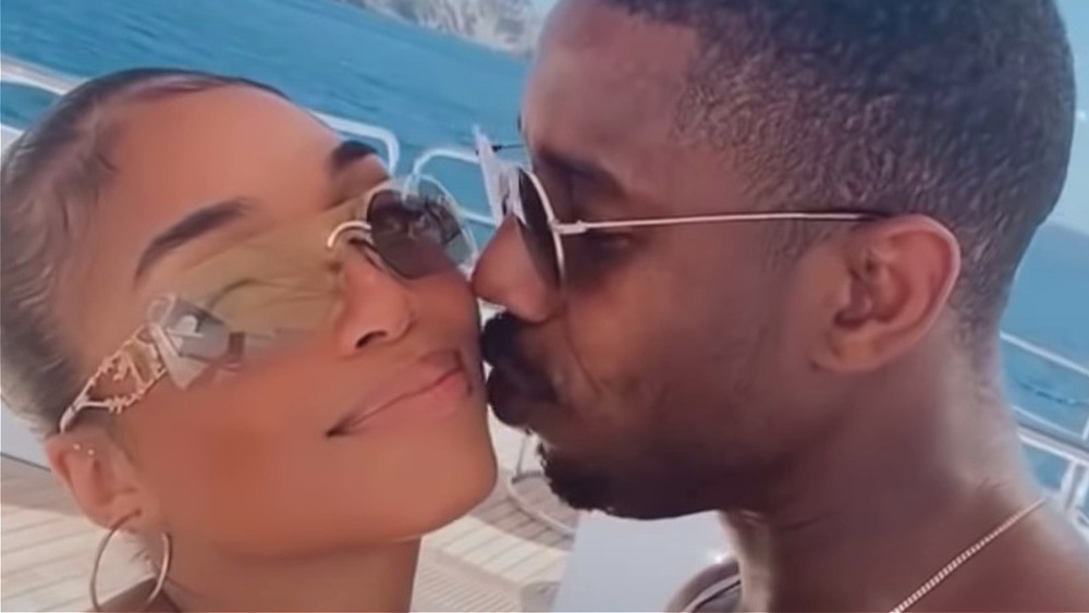 Michael B. Jordan kissing Lori Harvey on the cheek on a yacht 