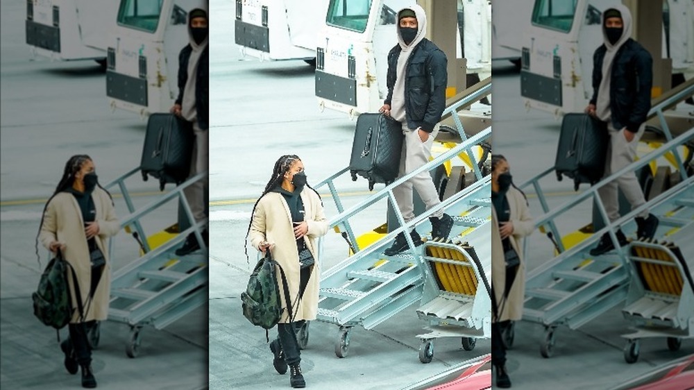 Michael B. Jordan and Lori Harvey wearing masks and getting off a plane in Utah