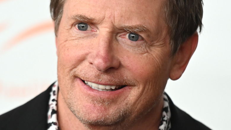 Michael J. Fox smiles in a dark jacket.