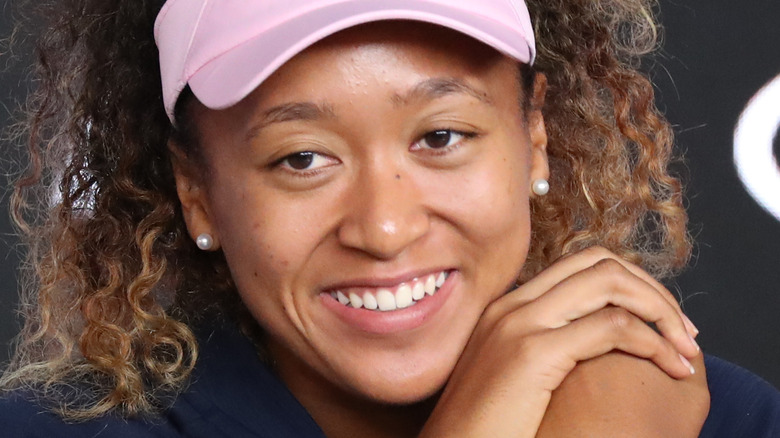 naomi osaka smiling hands on face