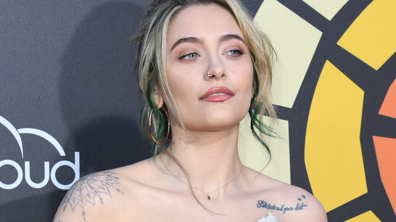 Paris Jackson looking up against media wall