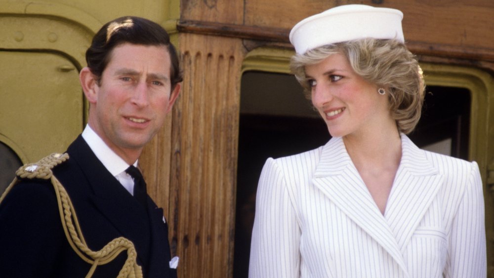 Prince Charles looking straight ahead as Princess Diana smiles at him